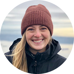 Emma smiling in toque by ocean